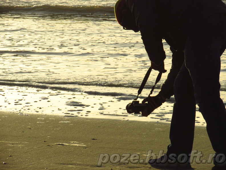 Fotograf cauta pozitia perfecta plaja marea nordului